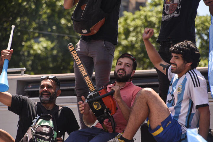 Manifestantes en plaza congreso festejan la asunción presidencial de Milei con una motosierra 