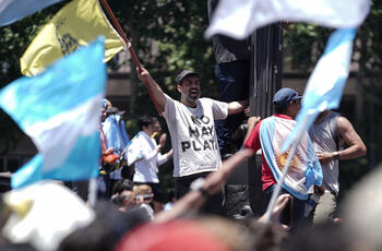 Un manifestante de La libertad avanza viste una remera que dice "no hay plata" el día que asume Milei su presidencia 2023